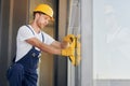 Side view. Young man working in uniform at construction at daytime Royalty Free Stock Photo