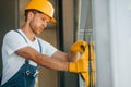 Side view. Young man working in uniform at construction at daytime Royalty Free Stock Photo
