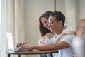 Side view of young people using laptop at home with happiness. Boy and girl living together and working on a notebook computer Royalty Free Stock Photo