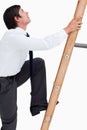 Side view of young tradesman climbing a ladder Royalty Free Stock Photo