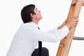 Side view of young tradesman climbing on a ladder