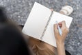 Side view of young woman concentrated drawing on her notebook while enjoying Royalty Free Stock Photo