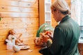 Side view of young woman craftsman decorating newborn baby doll with sponge while sitting in workshop at home. Royalty Free Stock Photo