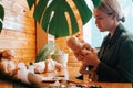 Side view of young woman craftsman decorating realistic dolls of newborn children using paints, Royalty Free Stock Photo