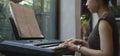 Side view of young woman focusing on sheet music playing electric piano at home