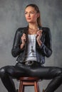 Side view of young woman holding leather jacket`s collar Royalty Free Stock Photo