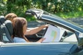Woman Looking At Map While Man Driving Car