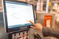 Side view of young woman paying at self-checkout using smartphone app at store