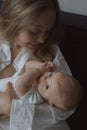 Side view of a young woman playing with her little baby in bed Royalty Free Stock Photo