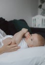 Side view of a young woman playing with her little baby in bed Royalty Free Stock Photo