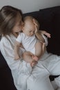 Side view of a young woman playing with her little baby in bed Royalty Free Stock Photo