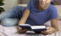 side view of a young woman reading a book lying in her bed. The concept of recreation, education and time for yourself Royalty Free Stock Photo