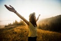 Side view of young woman with stretching arms enjoying nature and sunlight on top of hill Royalty Free Stock Photo