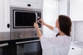 Woman Using Microwave Oven Royalty Free Stock Photo