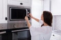 Woman Using Microwave Oven