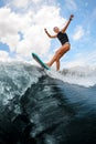 Side view of woman who jumping on the board wake surfing on the river against the cloudy sky Royalty Free Stock Photo