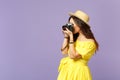 Side view of young woman in yellow dress, summer hat taking pictures on retro vintage photo camera isolated on pastel Royalty Free Stock Photo