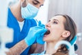 Young woman during painless teeth cleaning done by a reliable de