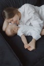 Side view of a young woman playing with her little baby in bed Royalty Free Stock Photo