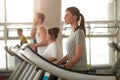 Side view young woman on treadmill at gym.