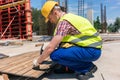 Side view of a young worker hammering a nail into wood during wo Royalty Free Stock Photo