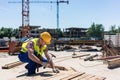 Side view of a young worker hammering a nail into wood during work Royalty Free Stock Photo