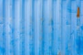 Side wall of marine cargo metal container, blue background, patina, scratches, rust