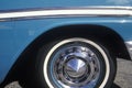 A side wheel and panel of a blue 1956 Chevrolet