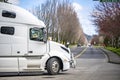 Side of white big rig semi truck turning o the local road for pick up the load Royalty Free Stock Photo