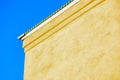 Side of white stucco building with metal roof and white accent paint with blue copy space clear sky in daylight sun Royalty Free Stock Photo