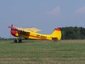 Side of yellow sport Yakovlev Yak-12M SP-AWG airplane lands on grassy airfield in european Bielsko-Biala city, Poland