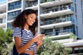 Side of young woman walking with cell phone outside Royalty Free Stock Photo