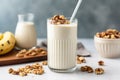 a sidebar view of a walnut banana smoothie with a metal spoon inside