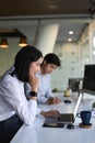 Businesswoman  working with laptop computer and sitting with her colleague at office desk. Royalty Free Stock Photo