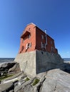 Sideview of crimson lighthouse with blue sky