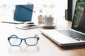 Sideview of office desk with laptop, glasses and other items Royalty Free Stock Photo