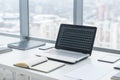 Sideview of office desktop with blank laptop and various tools. Royalty Free Stock Photo