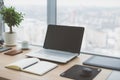 Sideview of office desktop with blank laptop and various tools. Royalty Free Stock Photo