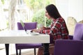 Sideview of young attractive woman typing on laptop on terrace