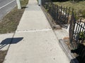 A sidewalk and black metal fence summer Royalty Free Stock Photo