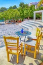 Sidewalk cafe with tables and yellow chairs, Crete, Greece