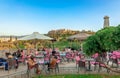 Sidewalk cafe in Thissio with Acropolis in the background.