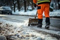 Sidewalk cleared by road worker in special attire, removing snow after snowstorm.