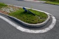 Sidewalk of concrete cubes at a crossing overgrown with weed flowers. neighborhood without regular maintenance. sidewalks difficul