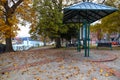 A sidewalk covered with fallen autumn leaves with red brick and cobble stone surrounded by gorgeous green and autumn colored trees Royalty Free Stock Photo