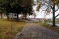 A sidewalk covered with fallen autumn leaves with red brick and cobble stone surrounded by gorgeous green and autumn colored trees Royalty Free Stock Photo