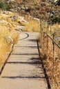 Sidewalk with metal hand rail and cement path in natural preserve area in wilderness or in nationl park in arizona Royalty Free Stock Photo