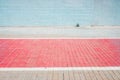 Sidewalk with a red painted bike path and white wall, nobody and single space