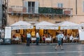 Sidewalk restaurant with tourists in Roman square a sunny summer