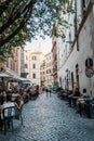 Sidewalk restaurant with tourists in Roman street a sunny summer